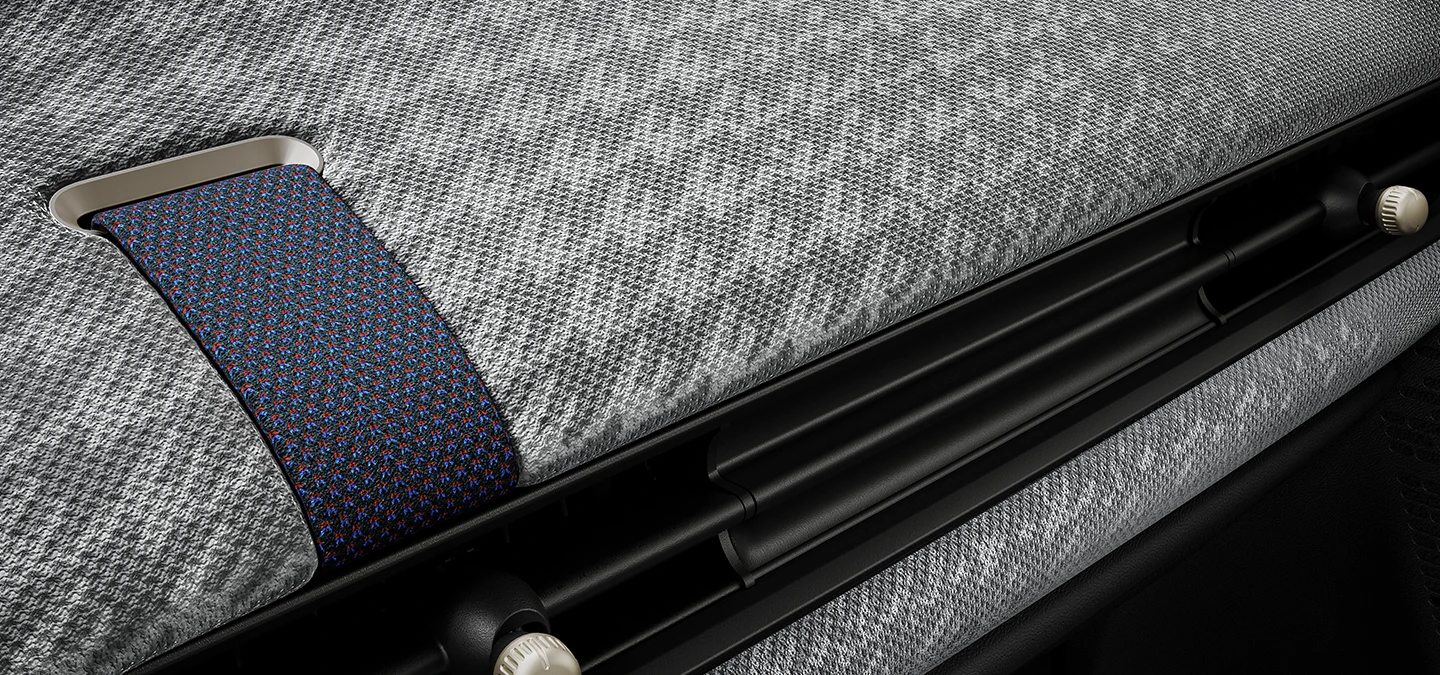 Vue rapprochée du tableau de bord façon tissu tricoté 2D à l'intérieur de la MINI Cooper.