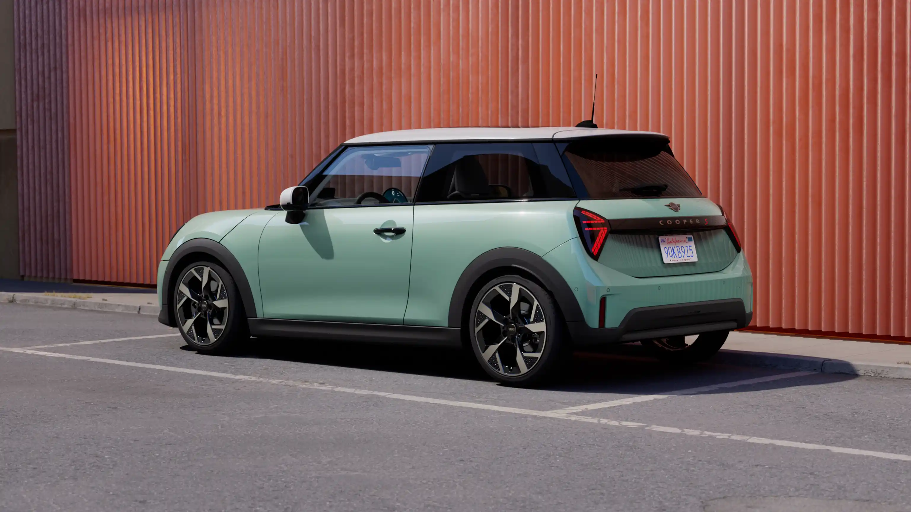 Vue arrière gauche d’une MINI Cooper 3 Portes Ocean Wave Green garée avec toit blanc