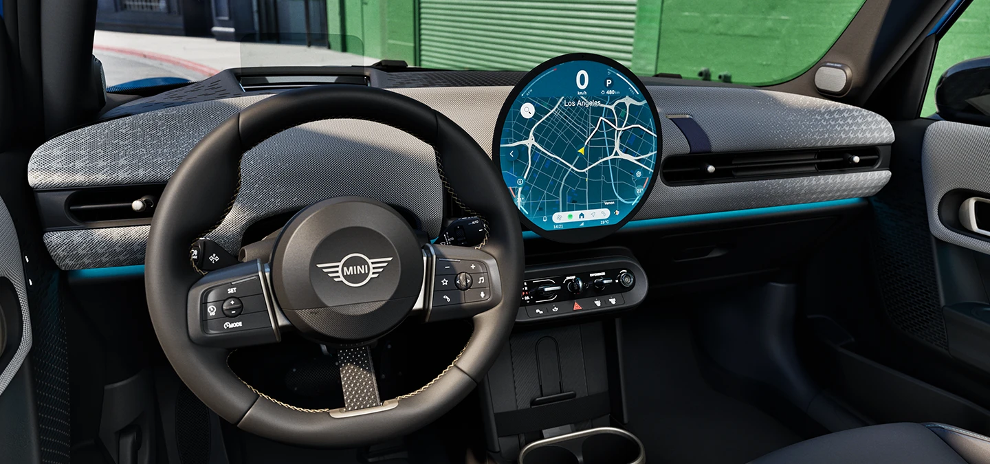 Vue de l'intérieur de la MINI Cooper 5 portes mettant l'accent sur le volant, le tableau de bord et l'unité d'interaction.