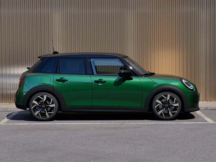 Vue latérale de la MINI Cooper 5 portes British Racing Green et toit noir en stationnement.