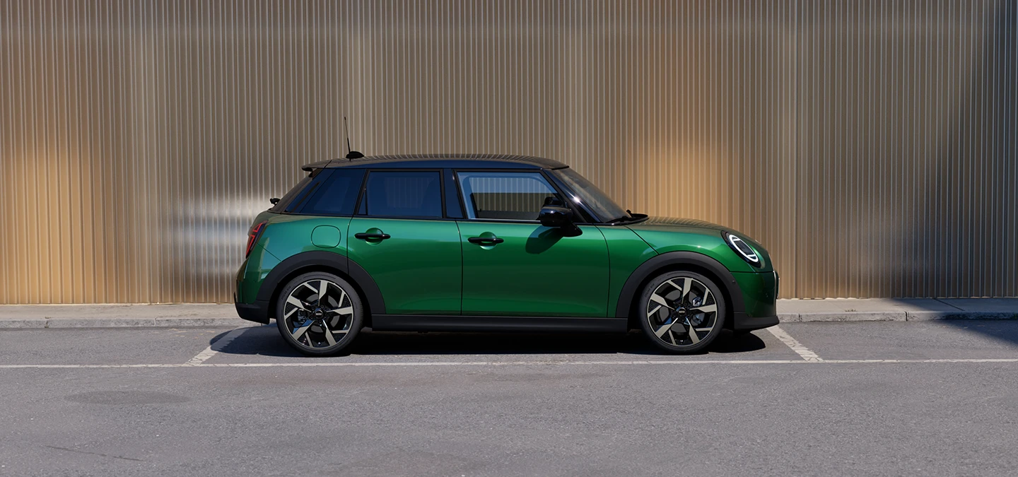 Vue latérale de la MINI Cooper 5 portes British Racing Green et toit noir en stationnement.