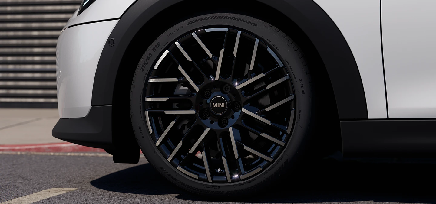 Plan rapproché de la MINI Cooper 5 portes Nanuq White avec jantes bicolores Night Flash Spoke.