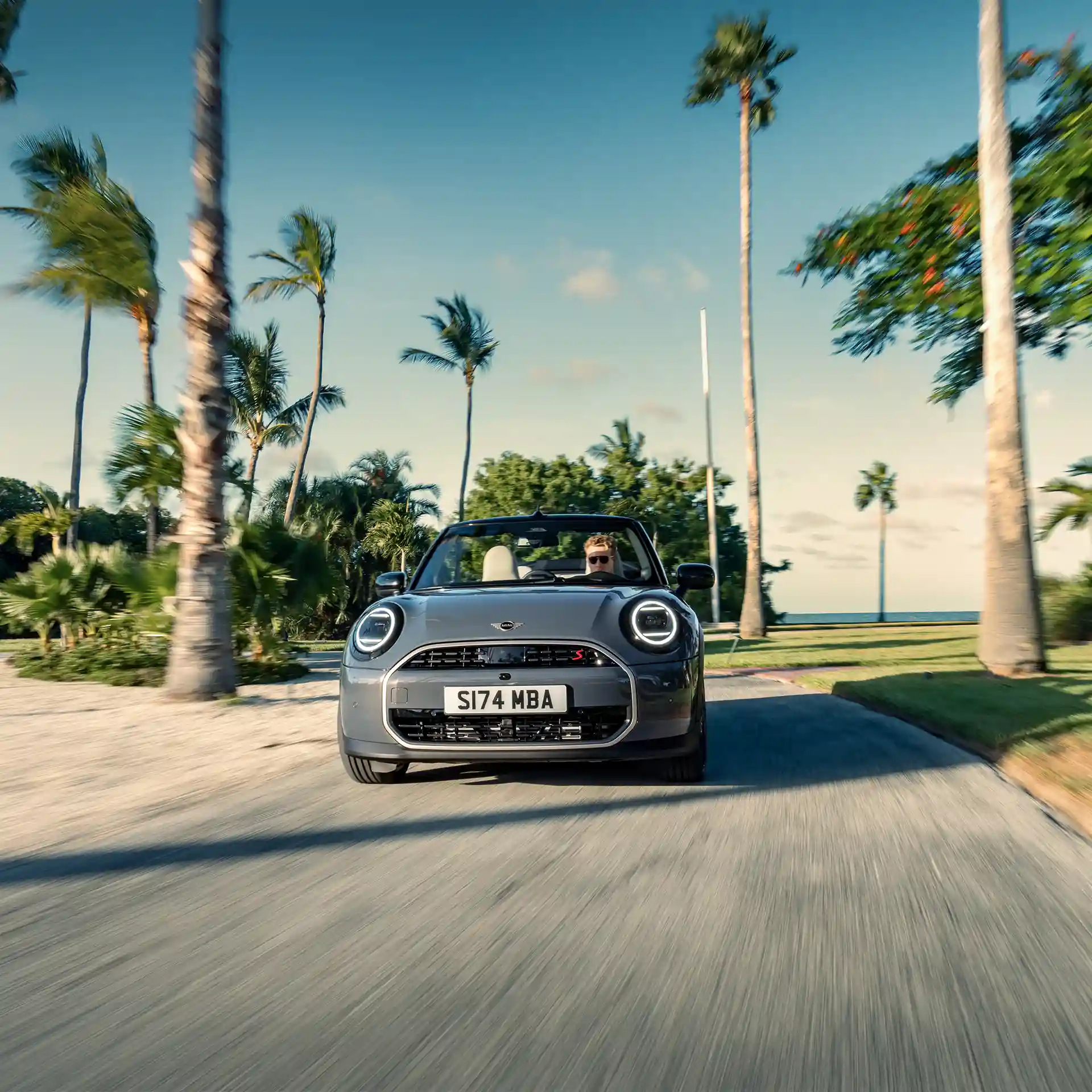 Vue avant d'une MINI Cooper Cabrio en marche en Copper Grey, sur la route