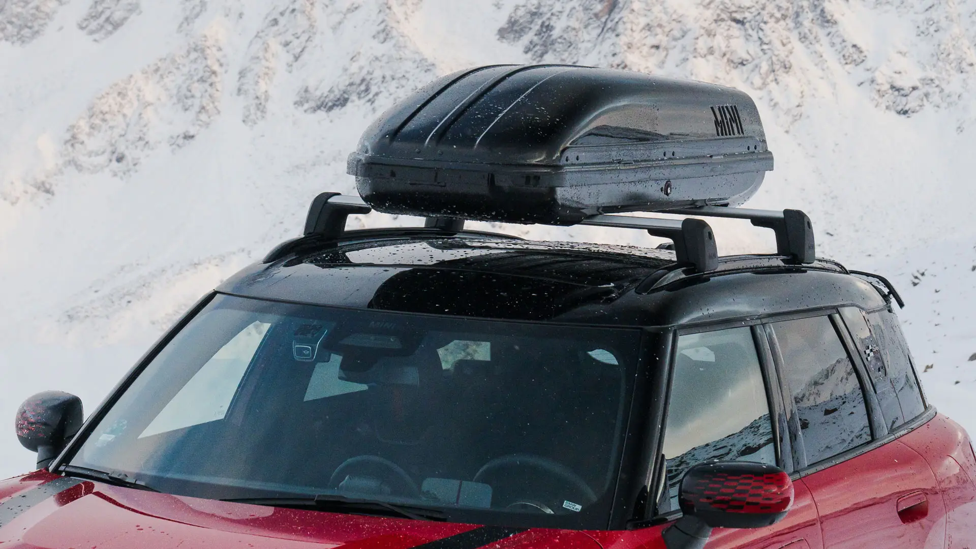 MINI Countryman en Chili Red II avec coffre de toit MINI 320 en noir.