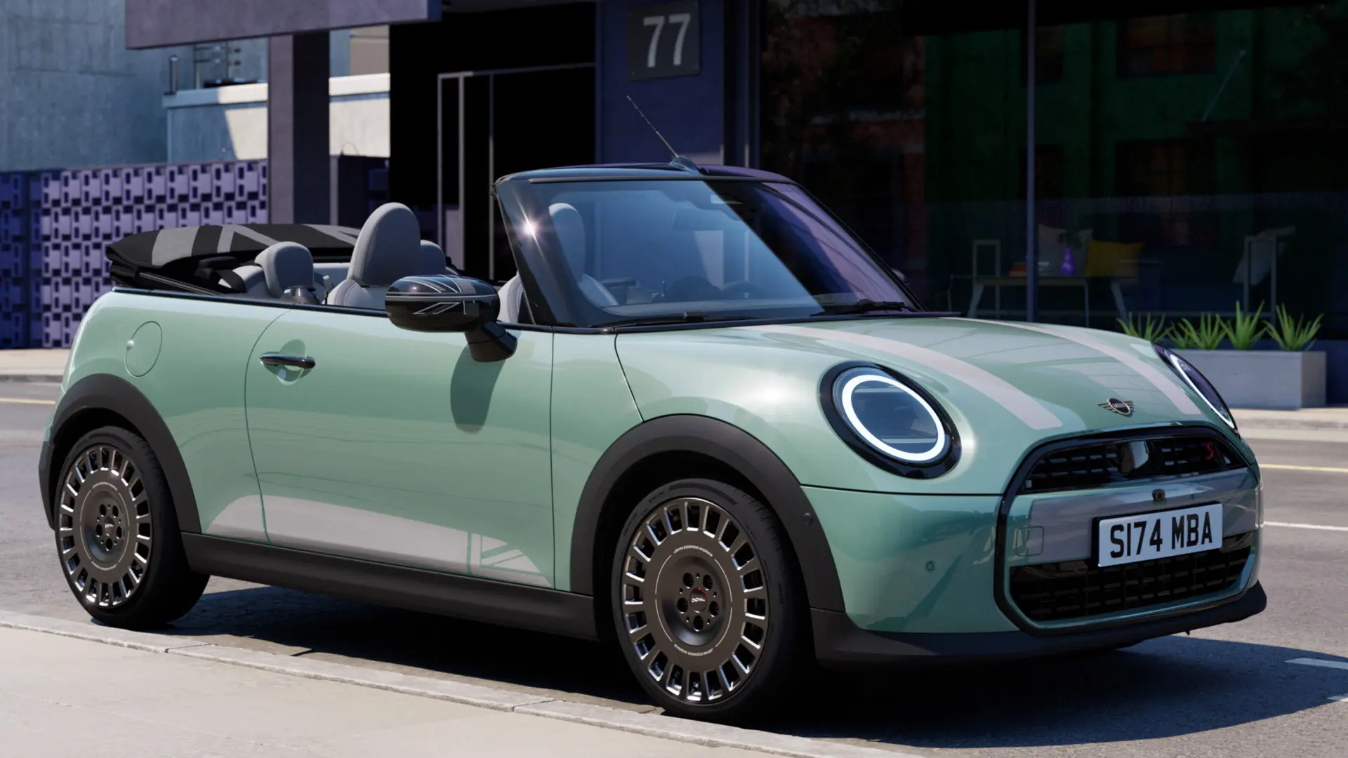 Vue latérale avant de la MINI Cabriolet en Ocean Wave Green avec autocollants pour capot blancs MINI Heritage. 
