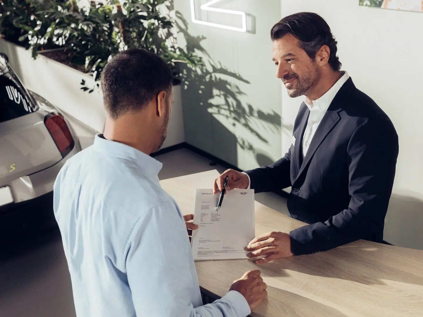 Un assistant d’entretien MINI conseille un client sur les options d’assurance pour les pneus MINI.