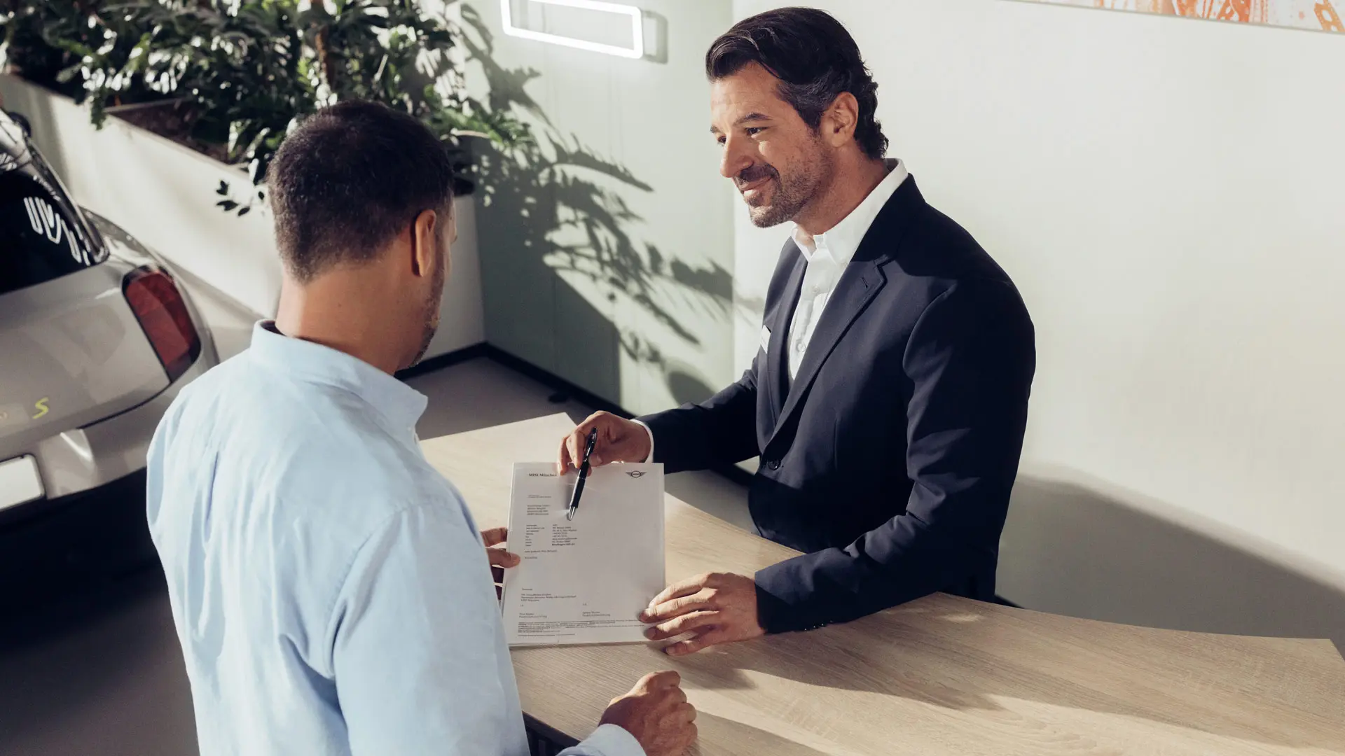 Un assistant d’entretien MINI conseille un client sur les options d’assurance pour les pneus MINI.