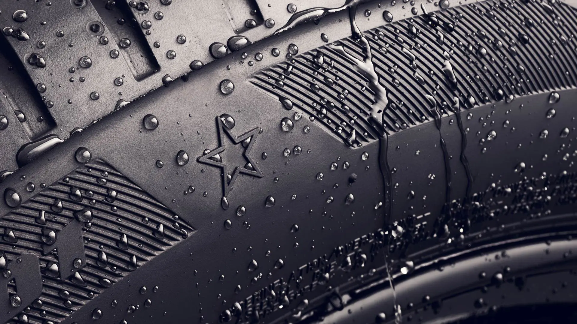 Gros plan sur le flanc d’un pneu portant le symbole de l’étoile, qui indique qu’il est homologué pour des performances optimales sur les véhicules MINI. 