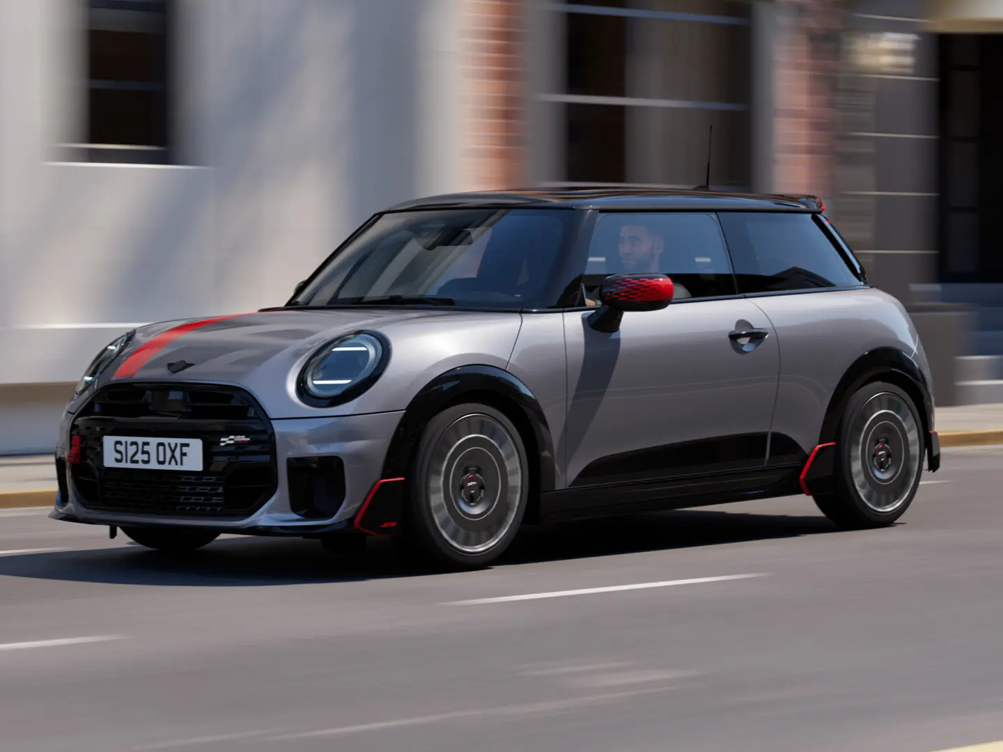 MINI Cooper 3 portes en Melting Silver avec coquille de rétroviseur John Cooper Works et film de capot Chili Red, becquet de toit et ailettes Black, roulant en ville, vue de face.