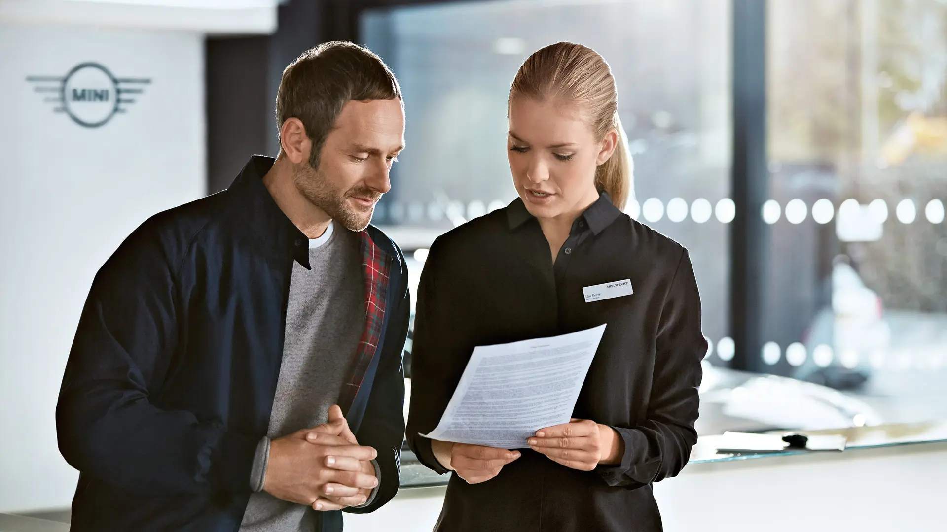 Un consultant MINI Service conseille un client sur les contrats d'entretien dans une concession MINI.